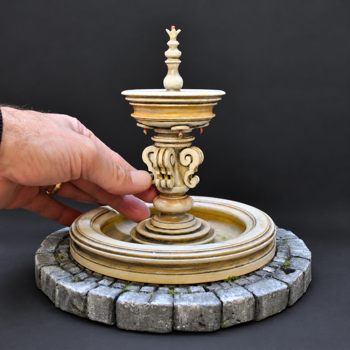 Fontana barocca in miniatura dipinta a mano, dettaglio con la mano per mostrare le dimensioni